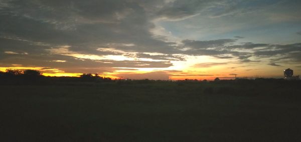 Scenic view of silhouette field against sky during sunset