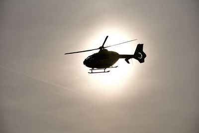 Low angle view of silhouette helicopter against sky