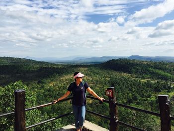 Full length of man standing on railing against mountains