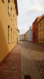 Empty alley amidst buildings in city