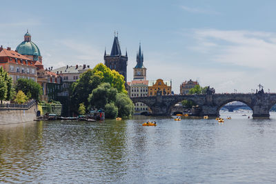 Arch bridge over river against buildings in city