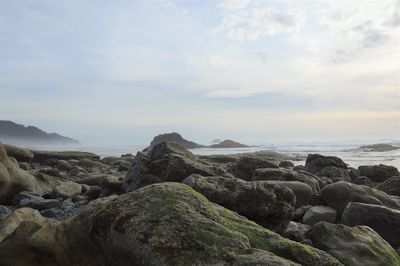 Rocks on beach against sky