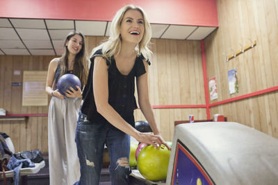 A young woman bowling.