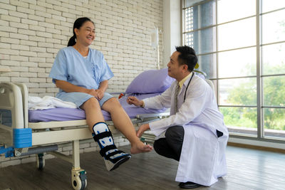 Side view of couple sitting at airport