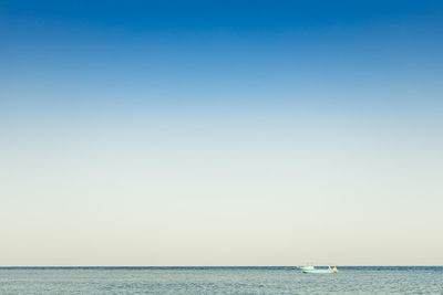 View to alone blue boat or ship yacht in silent sea or ocean water