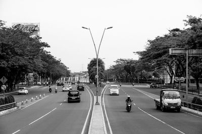 Cars on street in city against clear sky