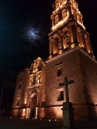 Low angle view of illuminated building against sky at night