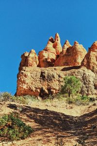 Low angle view of rock formations against blue sky