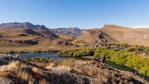 Scenic view of lake and mountains against clear sky