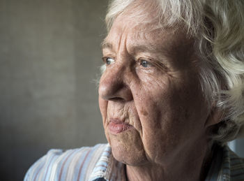 Close-up of thoughtful woman against wall