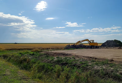 Big yellow excavator on an agriculural field