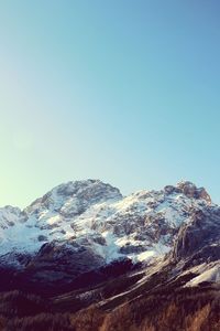 Low angle view of snowcapped mountains against clear sky