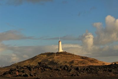 Lighthouse on mountain against sky