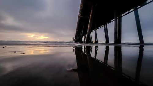 Bridge over sea against sky during sunset