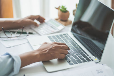 Midsection of man using laptop on table