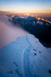 Aerial view of snow covered landscape during sunset