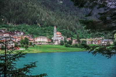 Scenic view of lake by buildings against trees