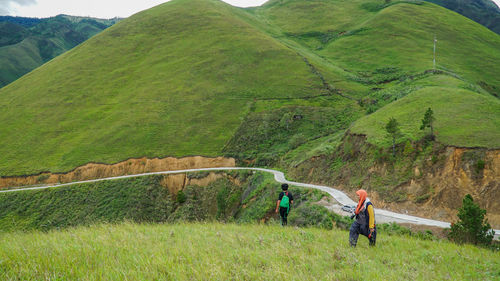 People on agricultural field against sky