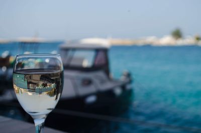 Close-up of glass against sea