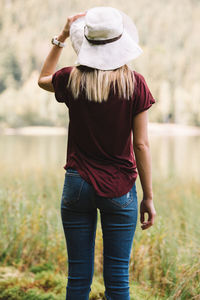 Rear view of woman standing in grass