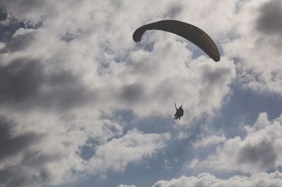 Low angle view of parachute against cloudy sky