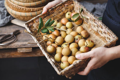 High angle view of person holding apple in basket