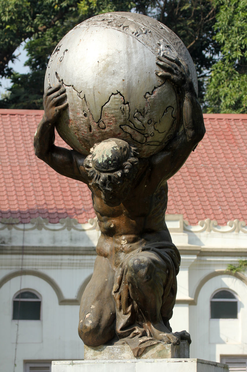 CLOSE-UP OF STATUE AGAINST BUILDINGS