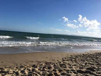 Scenic view of beach against blue sky