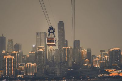 Illuminated buildings in city against sky