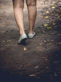 Low section of woman walking on footpath