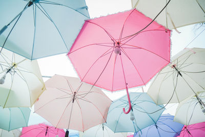 Low angle view of umbrellas hanging against sky