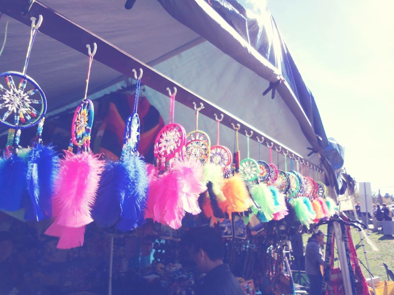 LOW ANGLE VIEW OF MULTI COLORED FLAGS HANGING AT MARKET