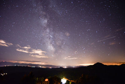 Scenic view of silhouette mountains against sky at night