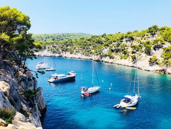 High angle view of sailboats moored in sea against clear sky