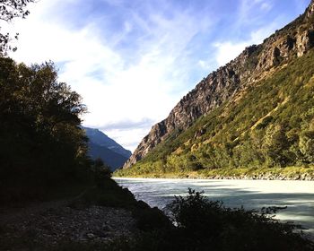 Scenic view of river against cloudy sky