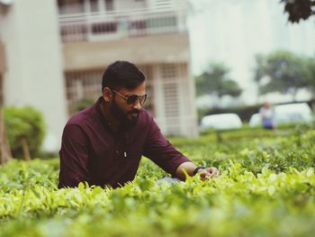 Side view of young man wearing sunglasses on field