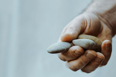 Cropped hand of man holding stones