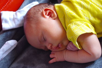 Close-up of cute baby girl sleeping on bed at home