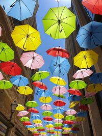 Low angle view of multi colored umbrellas hanging at market stall