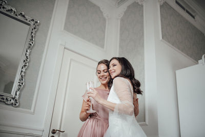 Bridesmaid and bride holding champagne flute