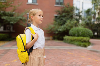 Cute boy looking away while standing outdoors