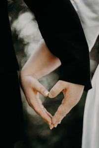 Midsection of couple holding hands