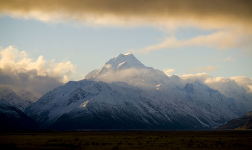 Scenic view of snowcapped mountains against sky during sunset