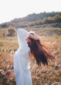 Woman with tousled hair standing on field