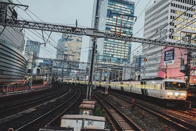 Railroad tracks in city against sky