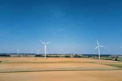 Windmill turbine in the field at summer day. rotating wind generator