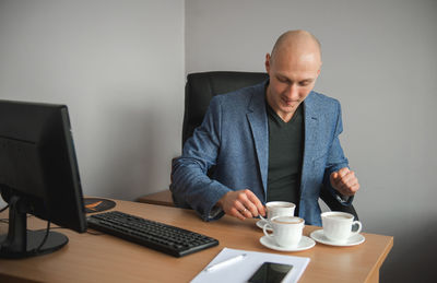 Businessman having coffee at desk in office