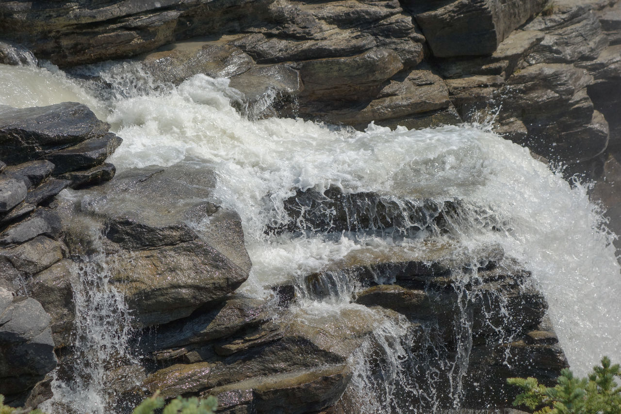 rock, water, waterfall, motion, water feature, beauty in nature, nature, rapid, stream, body of water, no people, splashing, scenics - nature, day, flowing water, land, river, sports, watercourse, outdoors, rock formation, long exposure, water sports, geology, flowing, blurred motion, non-urban scene, power in nature, high angle view, environment, boulder, wadi