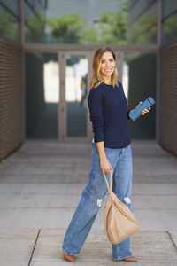 Portrait of young woman standing on hardwood floor