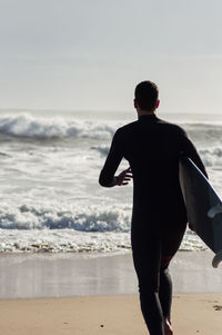 Rear view of man standing on beach